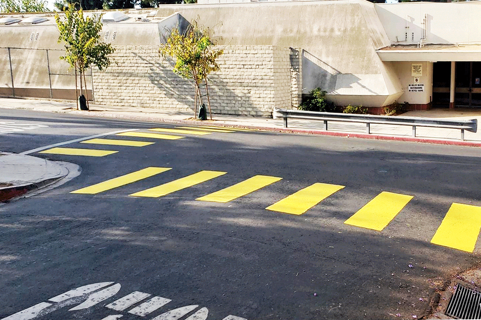 A GIF showing a lot before a crosswalk was painted, and then a picture of the lot with yellow crossing lines.
