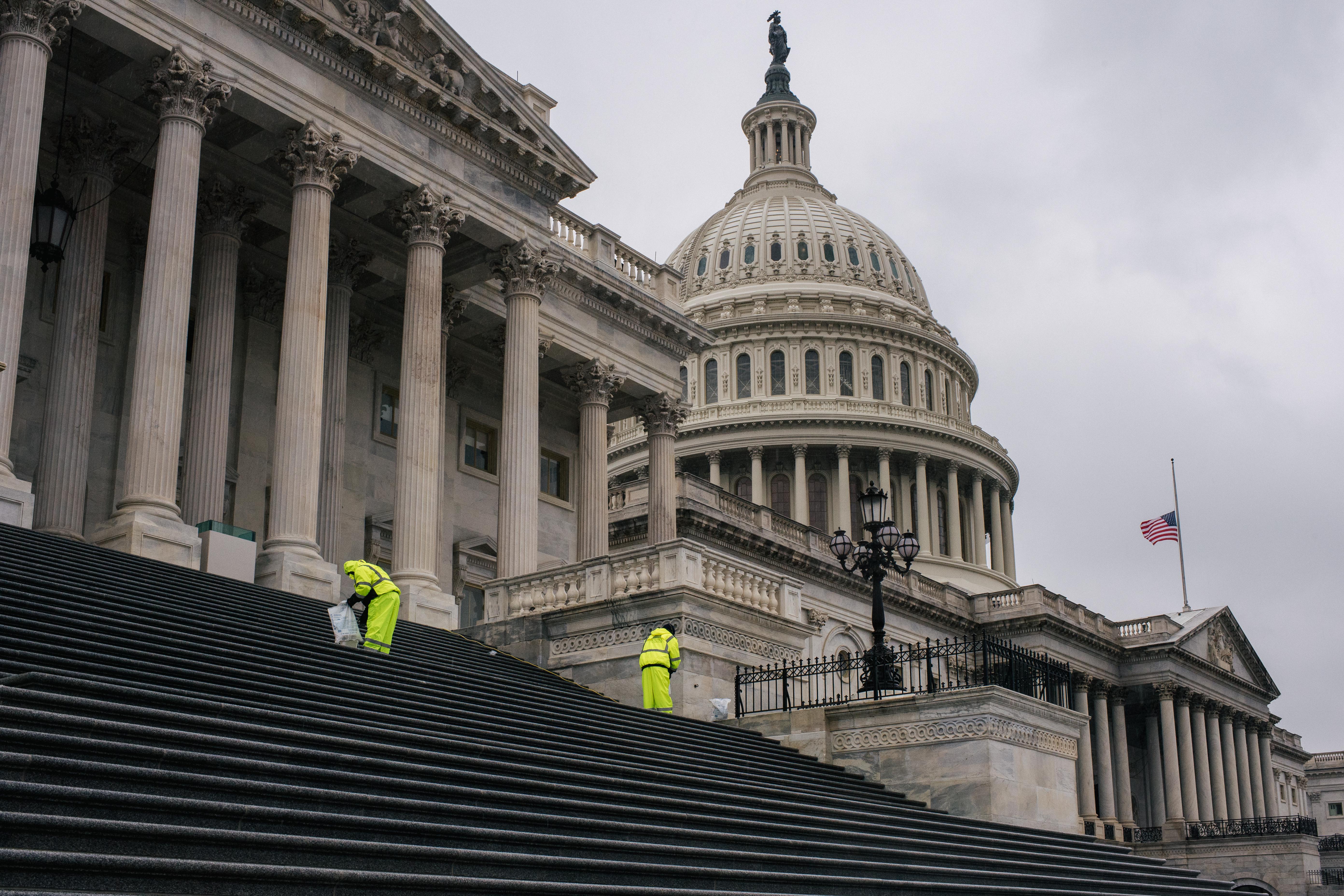 Employees salt the steps leading to the U.S. Capitol following the conclusion of the second impeachment trial of former President Donald Trump.