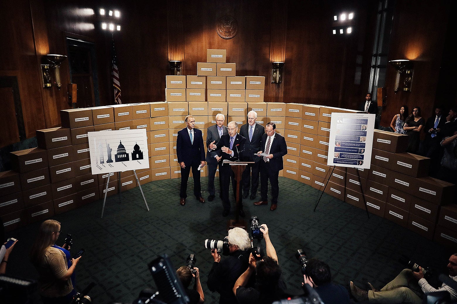 Republican members of the Senate Judiciary Committee stand in front of a wall of empty boxes labeled “Kavanaugh Files.”