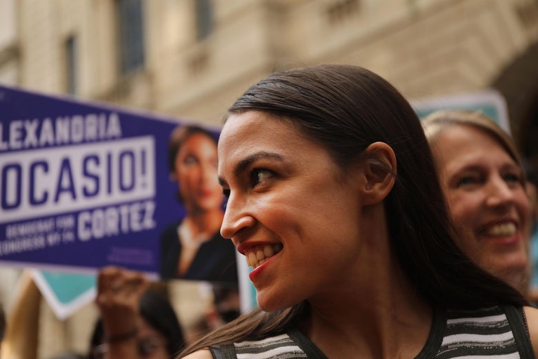 Alexandria Ocasio-Cortez surrounded by people outside of Wall Street office buildings