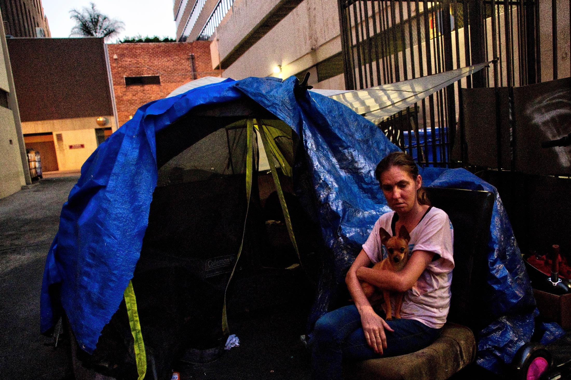 Jodan Wischmeier holds her dog outside of her home in an alley in Koreatown, Los Angeles.