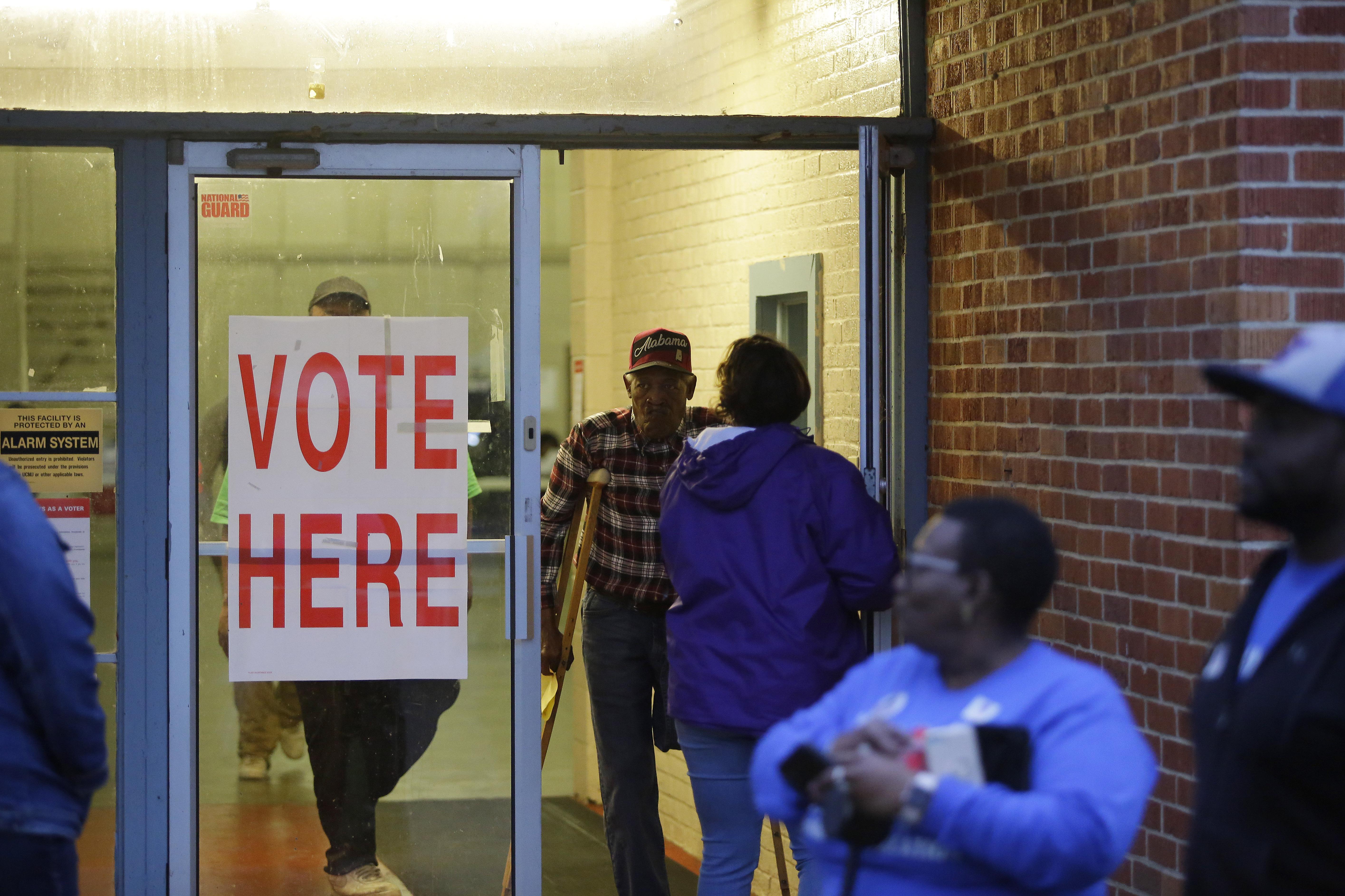 Alabama residents wait in line outside a polling station to cast a ballot.