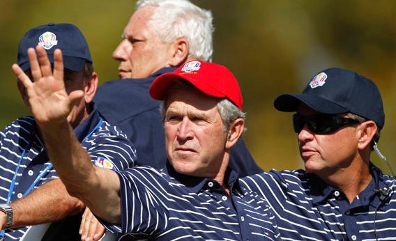 Former U.S. President George W. Bush (L) sits in a golf cart with U.S. captain Davis Love III during the afternoon four-ball round at the 39th Ryder Cup.