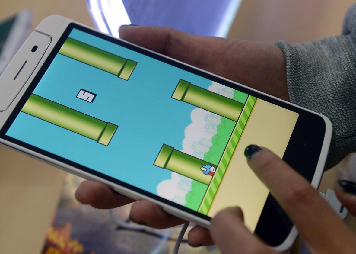 An employee plays the game Flappy Bird at a smartphone store in Hanoi on February 10, 2014. 