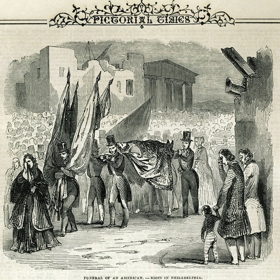 Image of a crowd with several members carrying a body.
