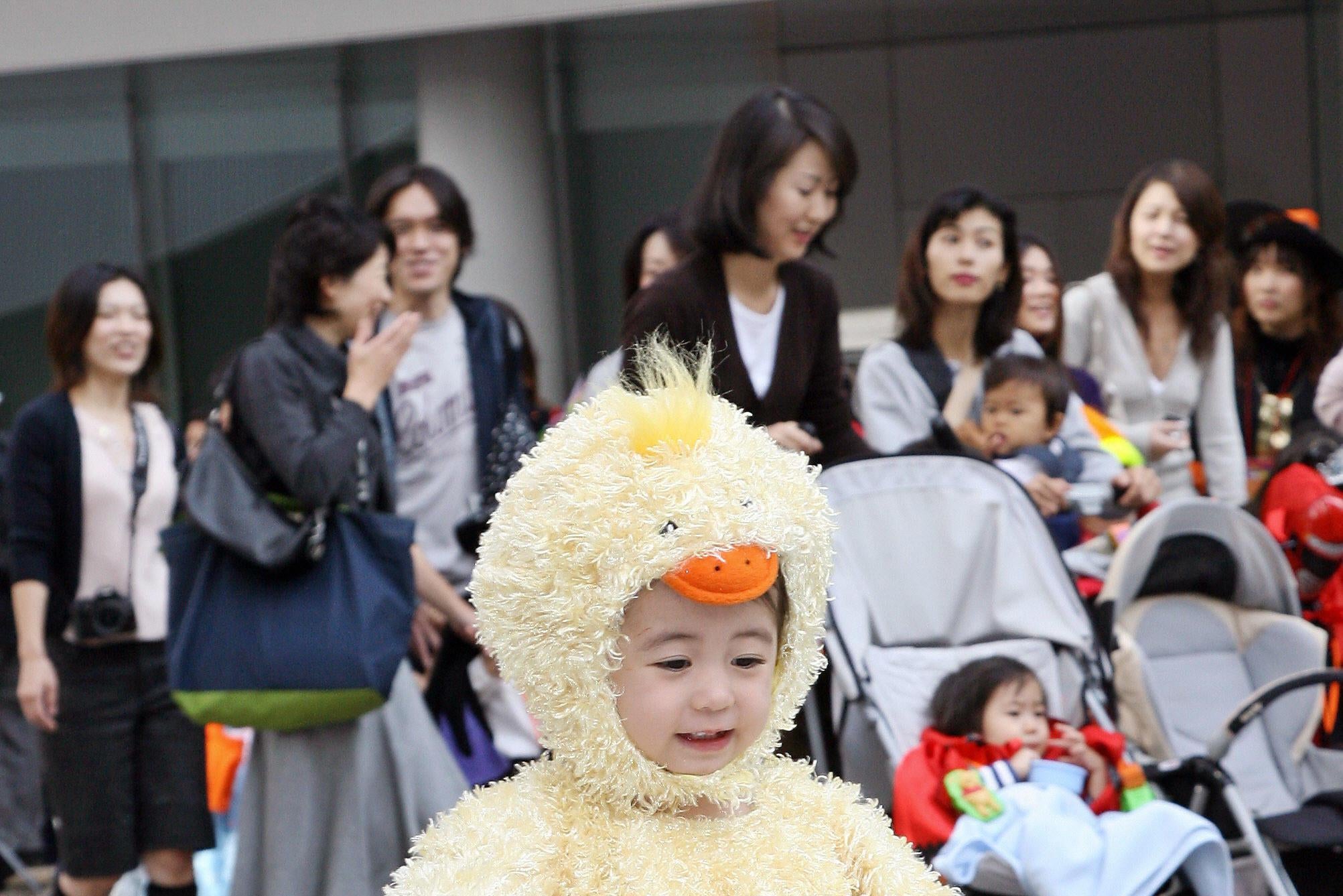 A little girl dressed as a baby chicken.