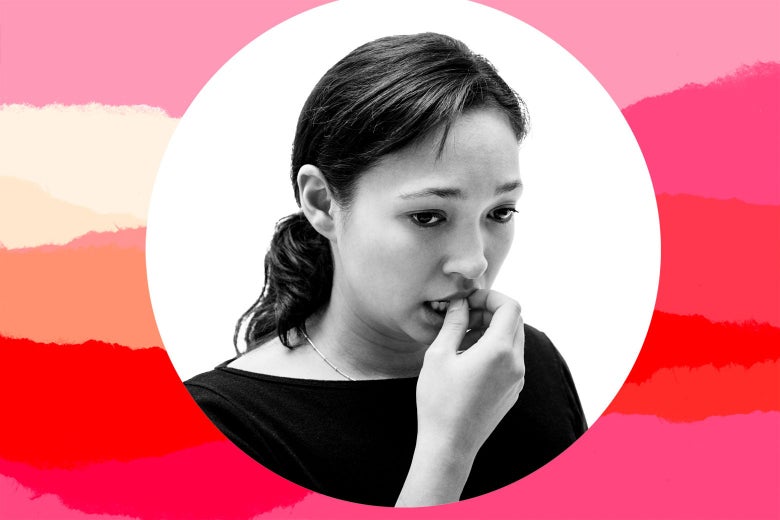 A woman holds her hand up to her mouth in concern.