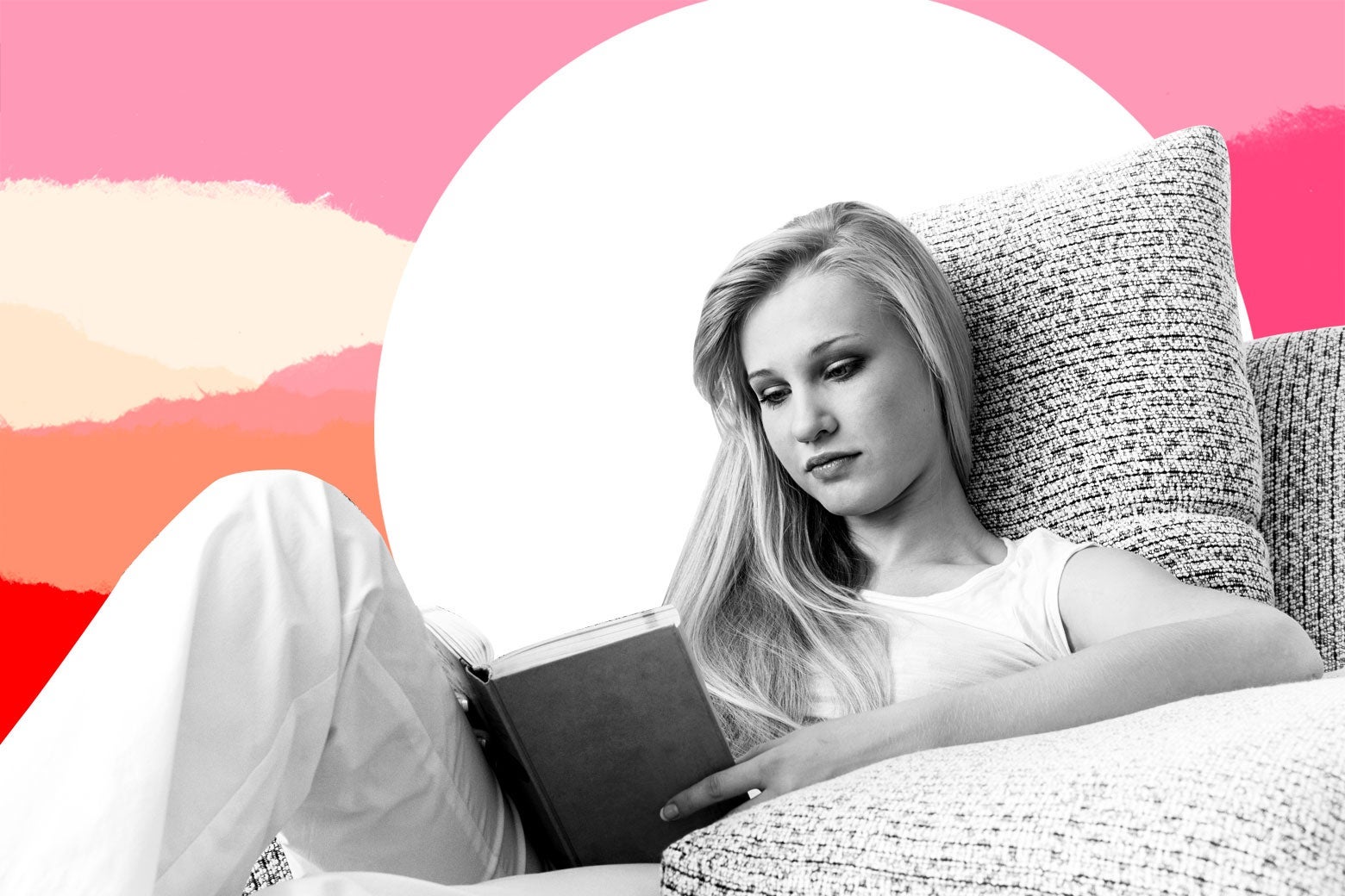 Teenage girl on a couch reading a book.