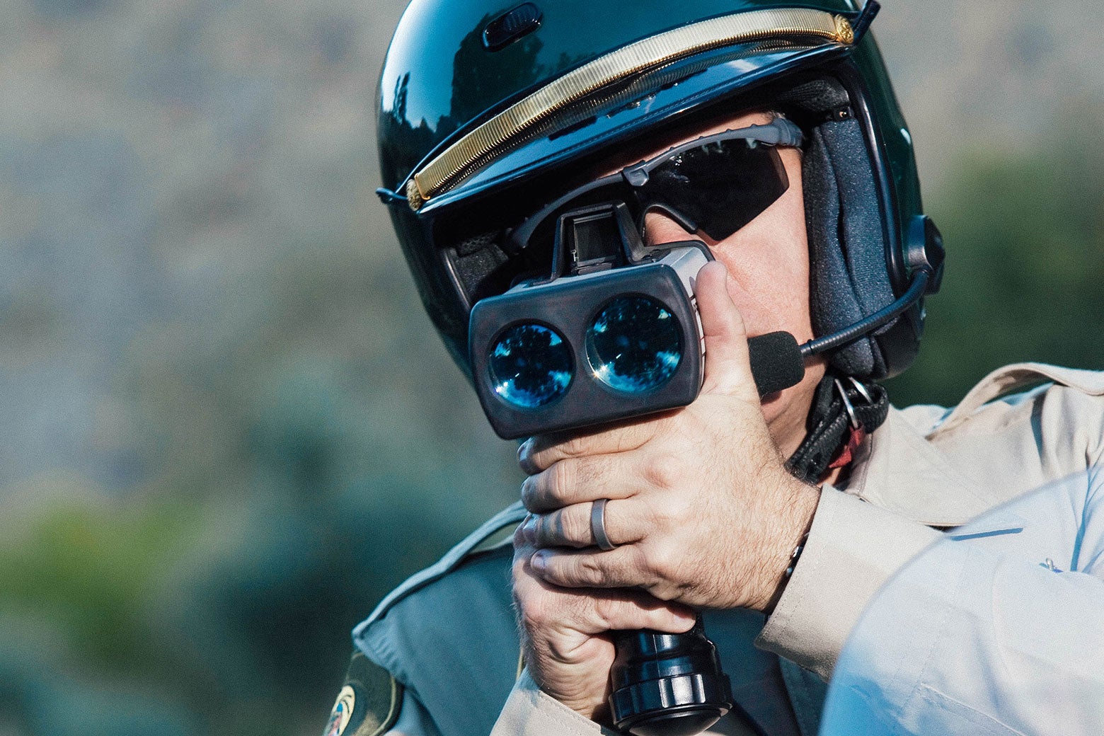 A law enforcement officer looks into a camera or radar device.