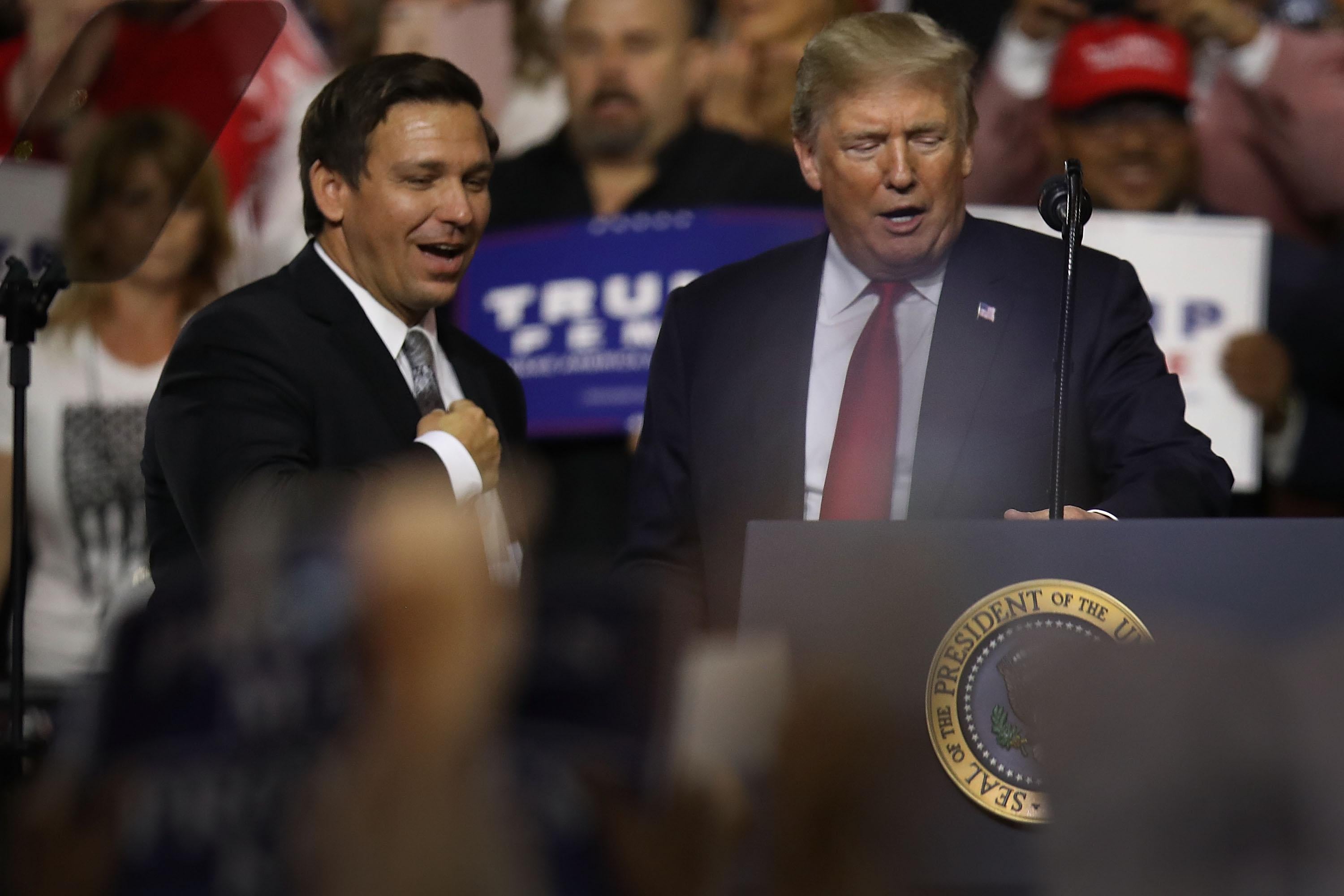 Donald Trump and Ron DeSantis on stage at a rally.