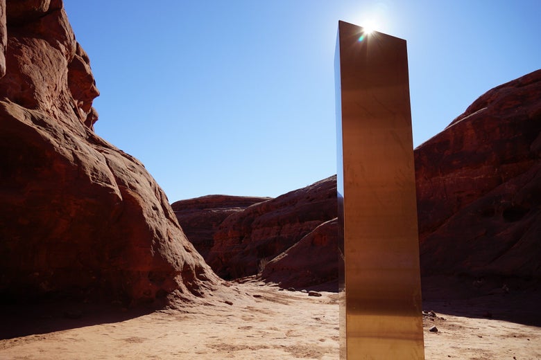 The "monolith" in the Utah desert, a large metal spire surrounded by red rock formations