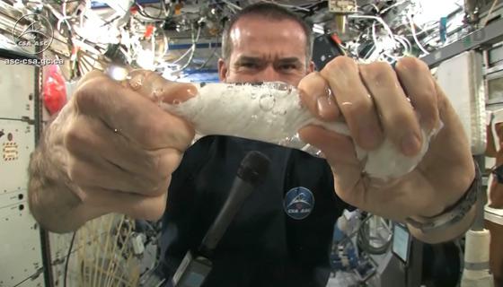 Chris Hadfield squeezing out a washcloth