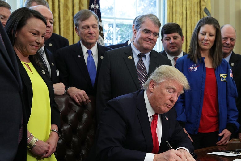 President Trump participates in a bill-signing ceremony as Rep. Martha Roby and others look on.