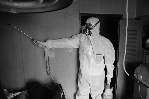 One of Koremura's workers sprays the room with an insecticide. 