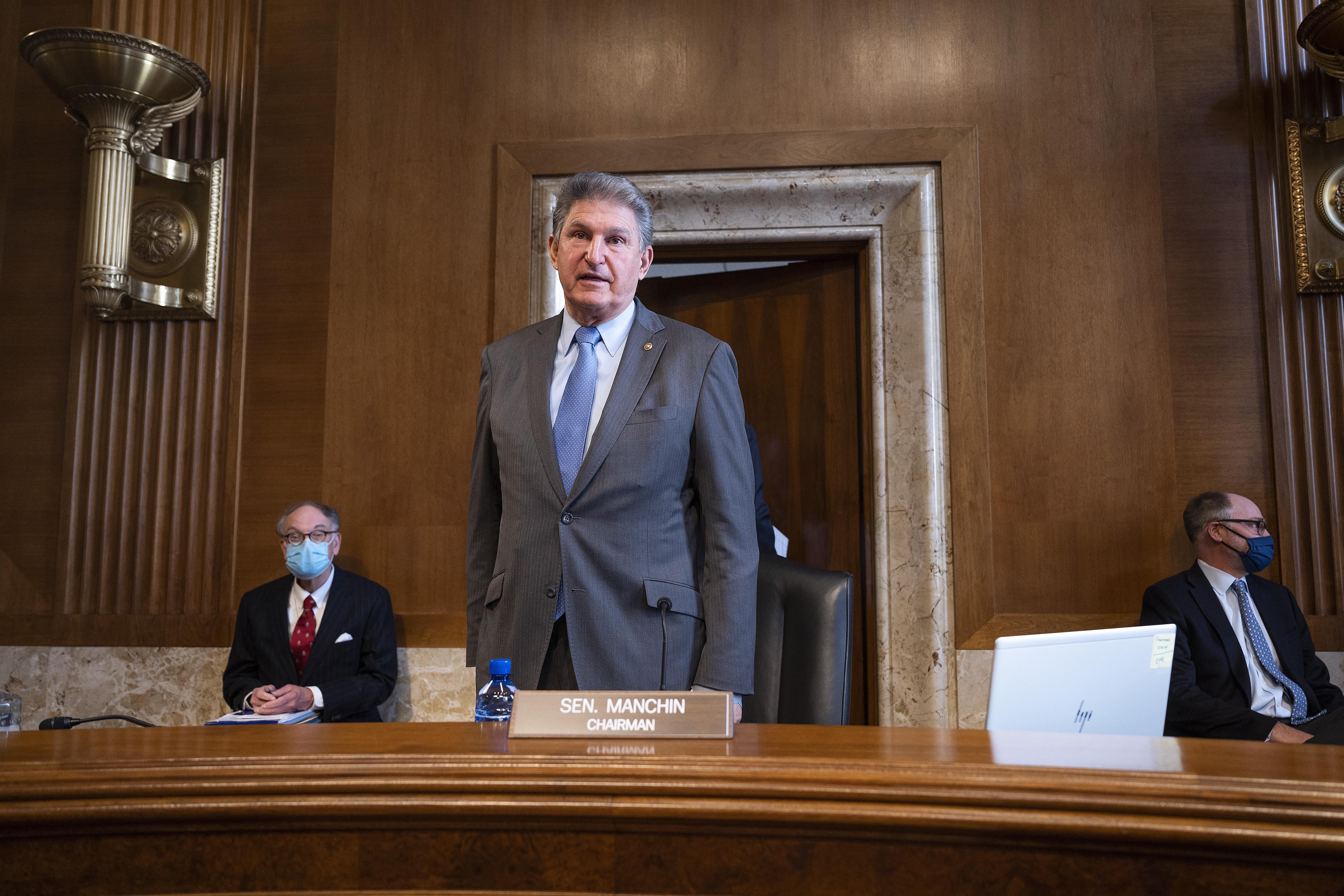 Manchin stands and speaks during a hearing