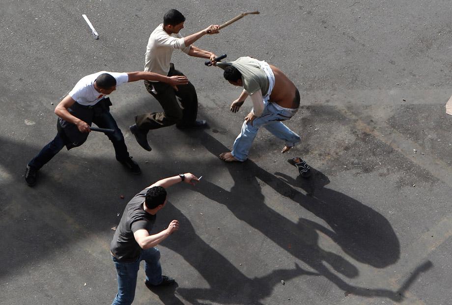 Plainclothes security personnel use batons to beat a protester at Cairo's Tahrir Square March 3, 2013.