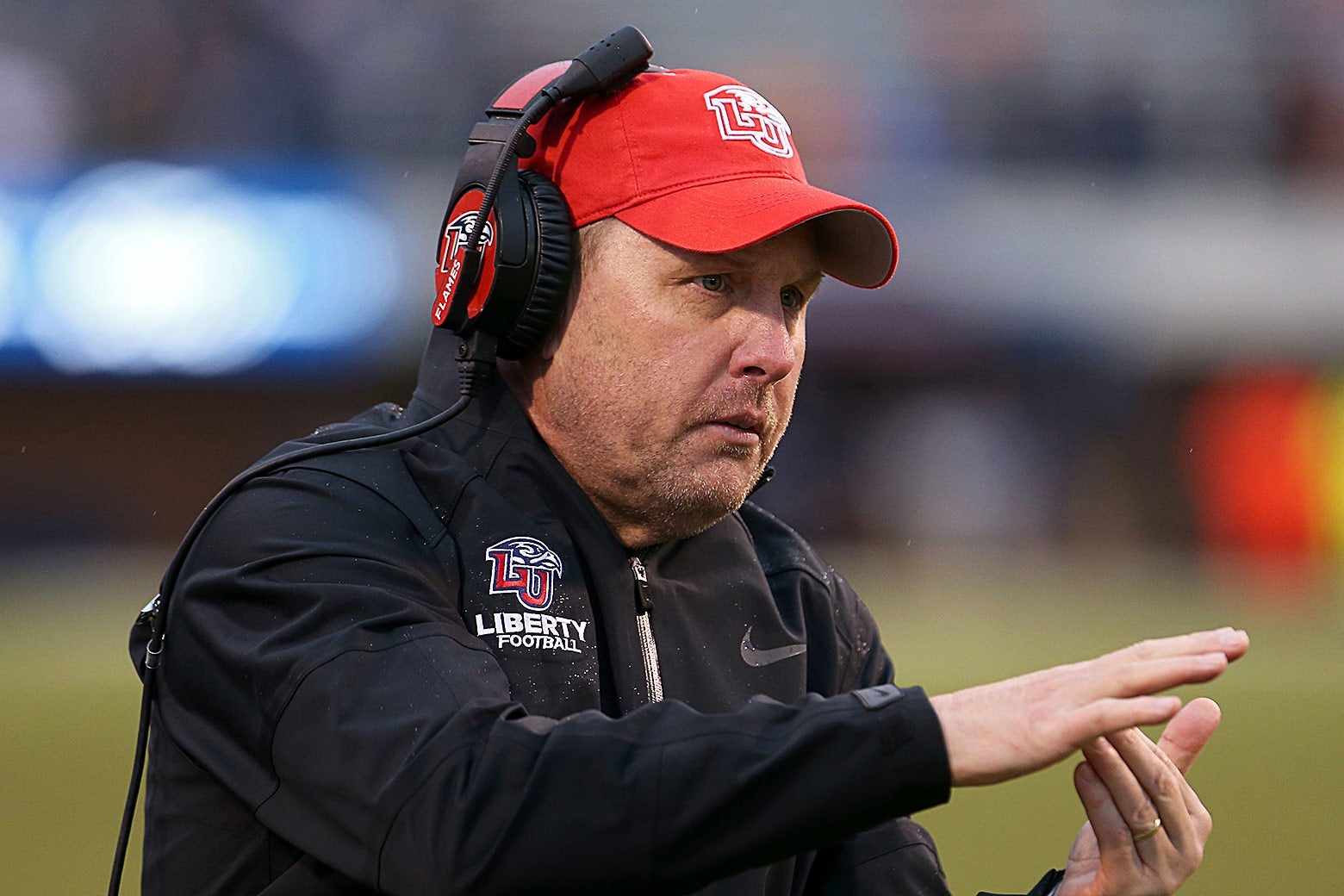 Hugh Freeze on the sidelines in a headset signals a timeout.