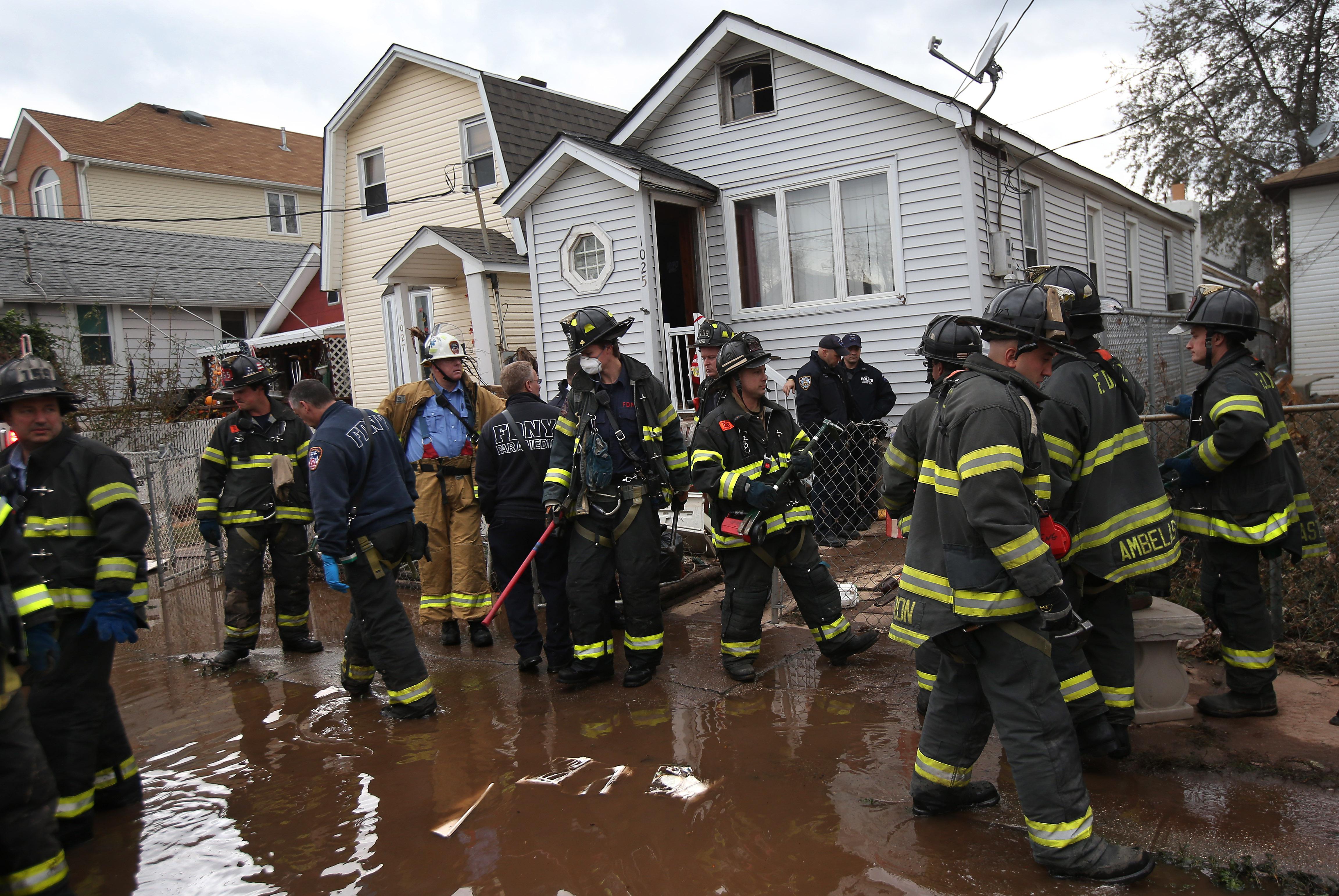 Firemen gather outside a house where the bodies of two elderly people were reportedly found on November 2, 2012 in the Staten Island borough of New York City.