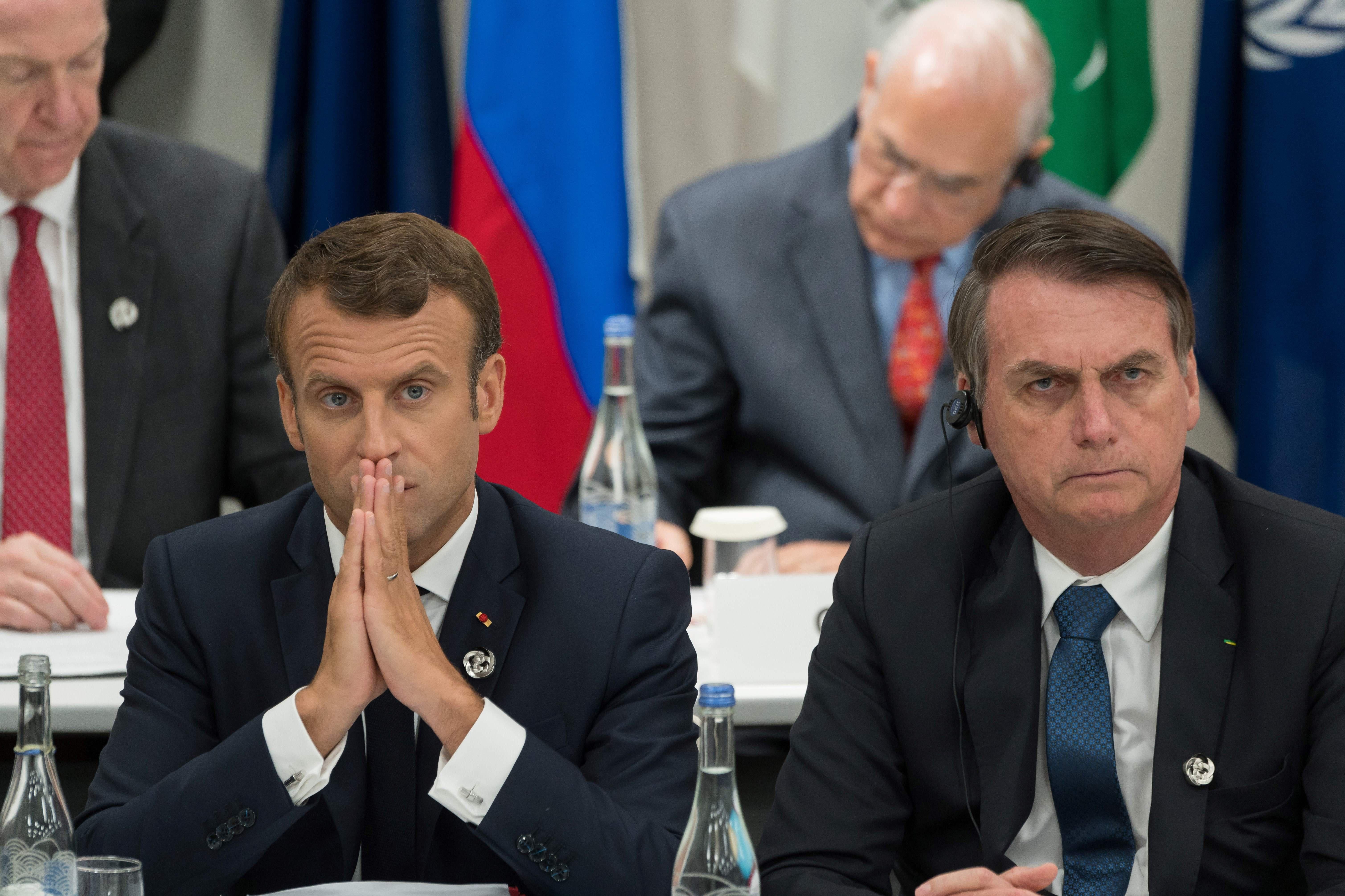 Emmanuel Macron and Jair Bolsonaro sitting next to each other.