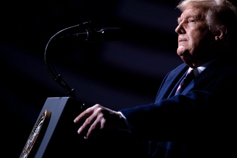 Trump pauses, gripping the podium, while speaking