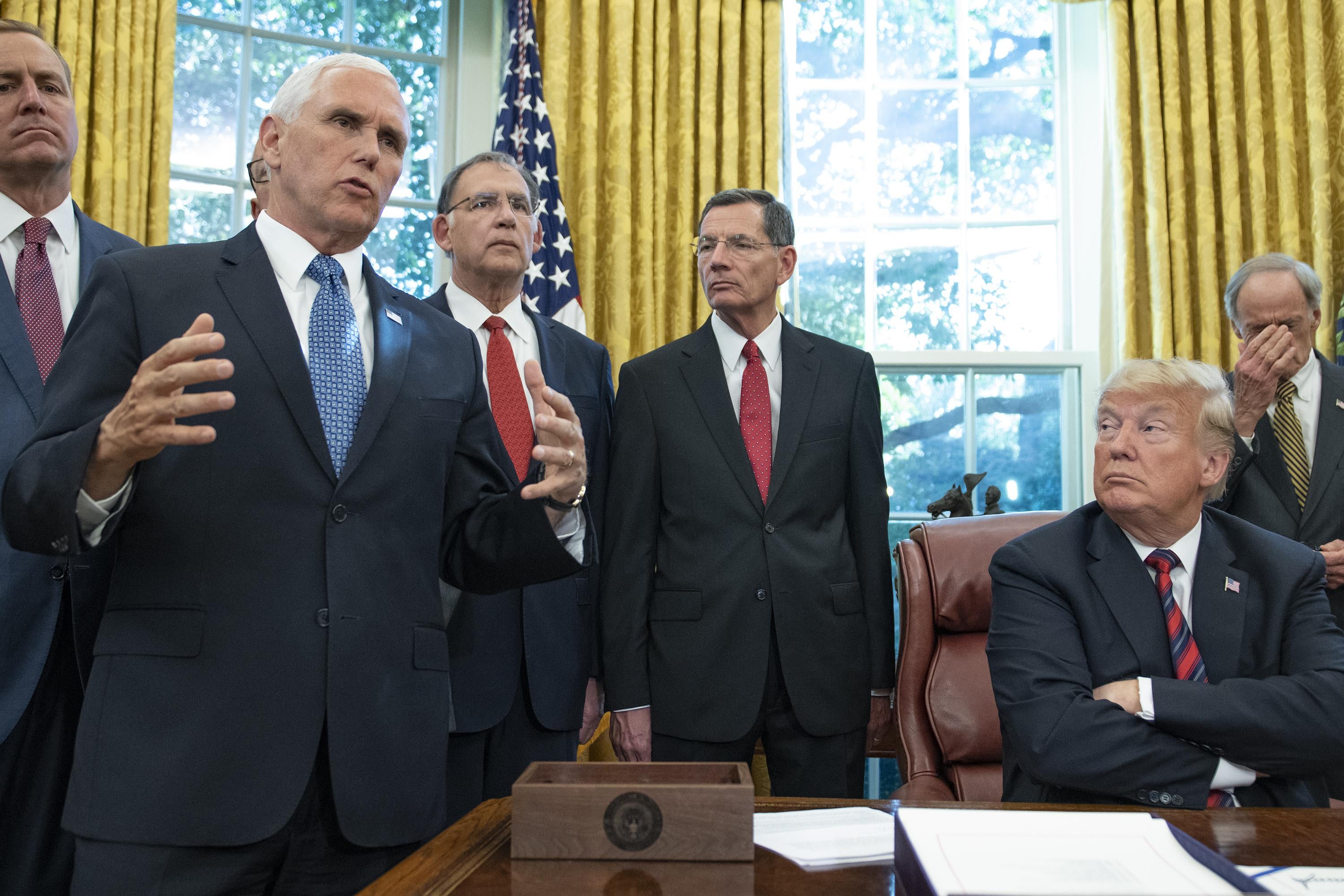 Vice President Pence speaks to the press pool as President Trump looks on in the Oval Office on October 23, 2018.
