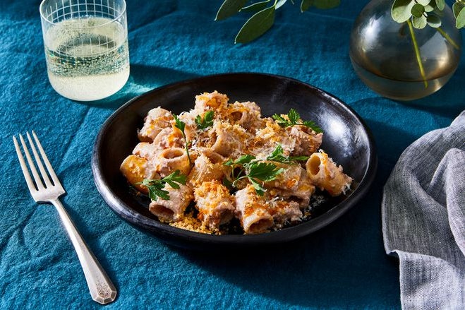 A bowl of pasta with crushed walnut sauce and Parmesan cheese.