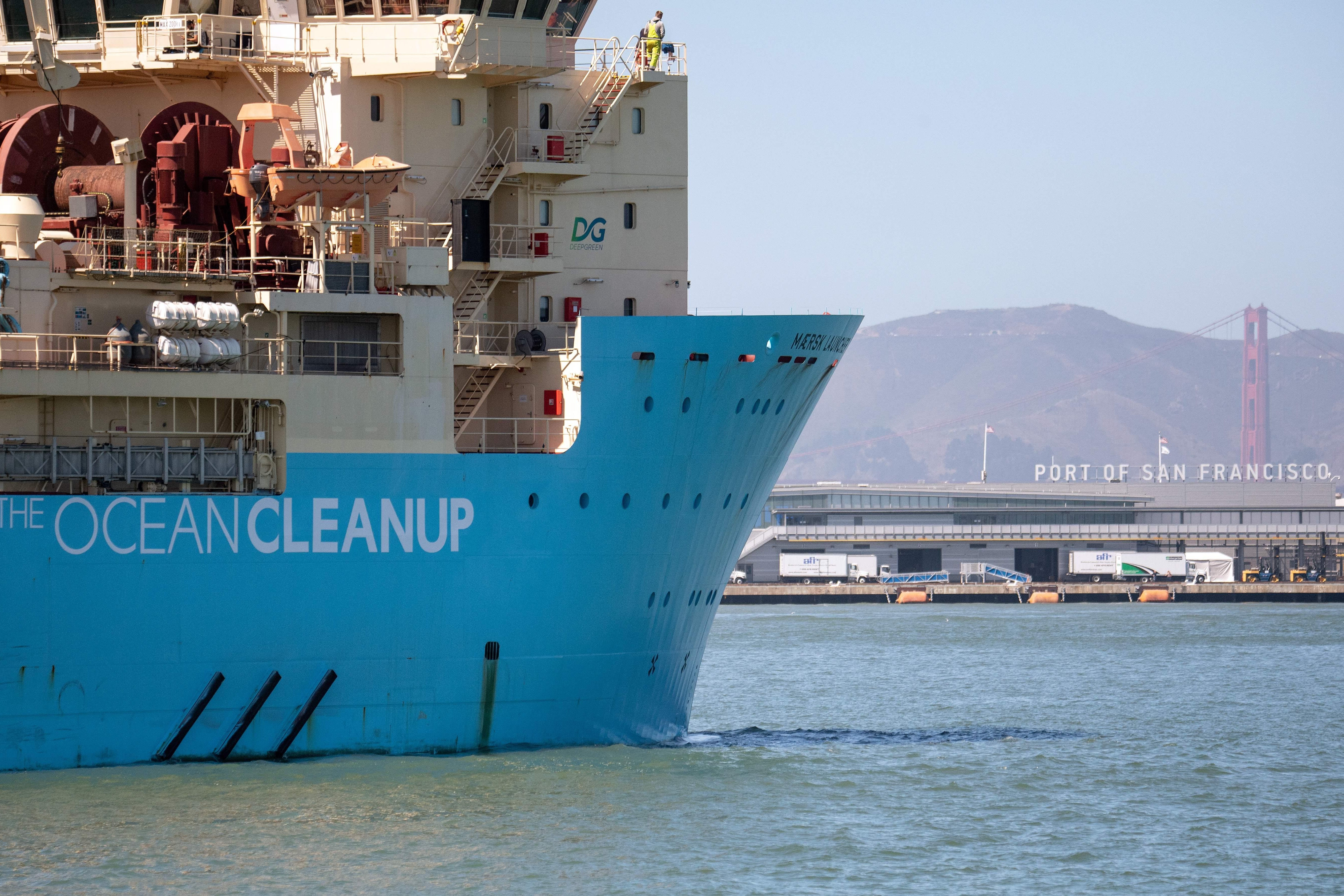 A blue vessel painted with the words "Ocean Cleanup" on the ocean, near the Port of San Francisco.