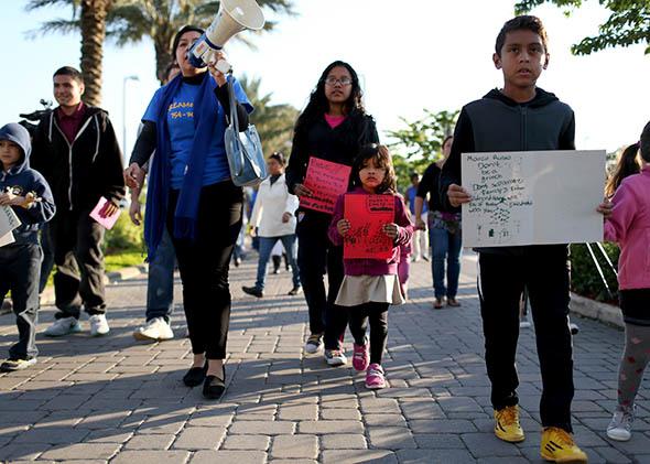 Pro-immigration reform demonstrators walk to the office of U.S. Sen. Marco Rubio.