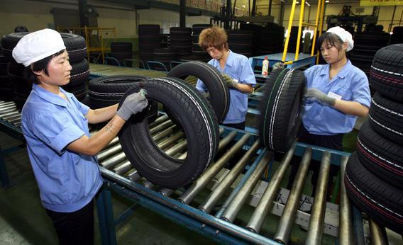Workers from the Hangzhou Zhongce Rubber Company conduct quality control checks on their tires at their factory in Hangzhou, in 2007. 