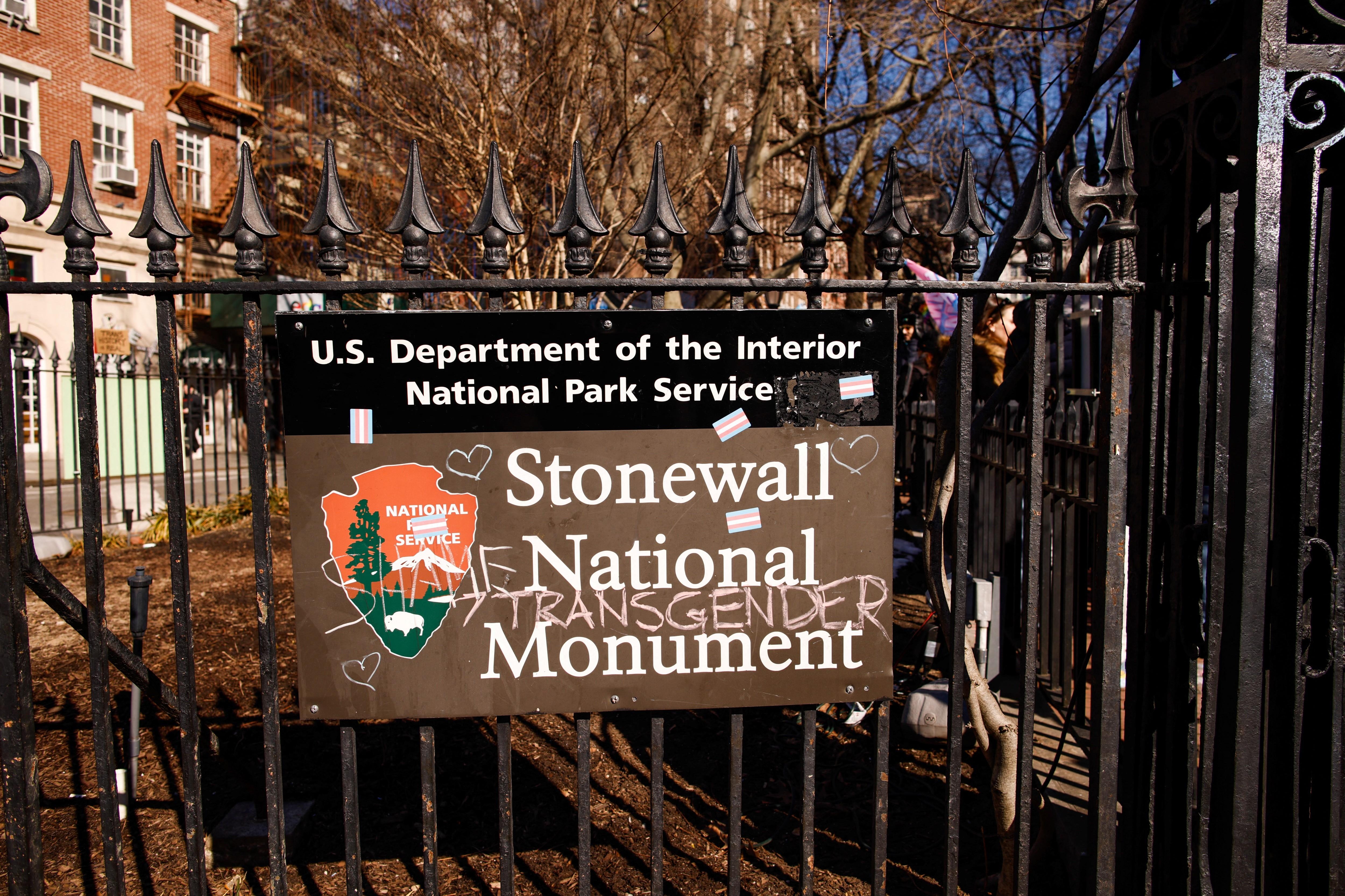 The Stonewall National Monument sign is seen as people protest outside the Stonewall Inn in New York.  