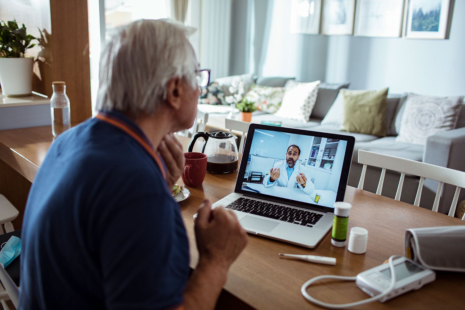 A senior speaking to a doctor on a laptop.