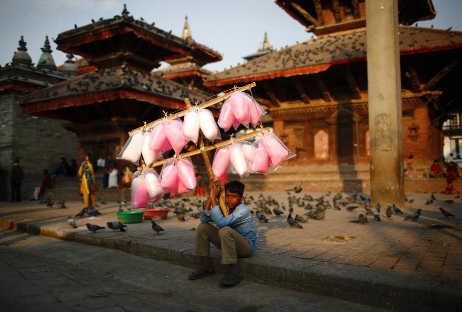 Satrohan Kumar Sahani, 12, sells cotton candy as he waits for customers along the street at Hanumandhoka Durbar Square in Kathmandu, Nepal on March 18, 2013. 