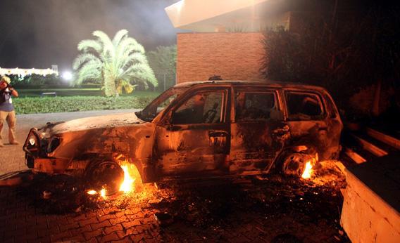 A vehicle sits smoldering in flames after being set on fire inside the US consulate.