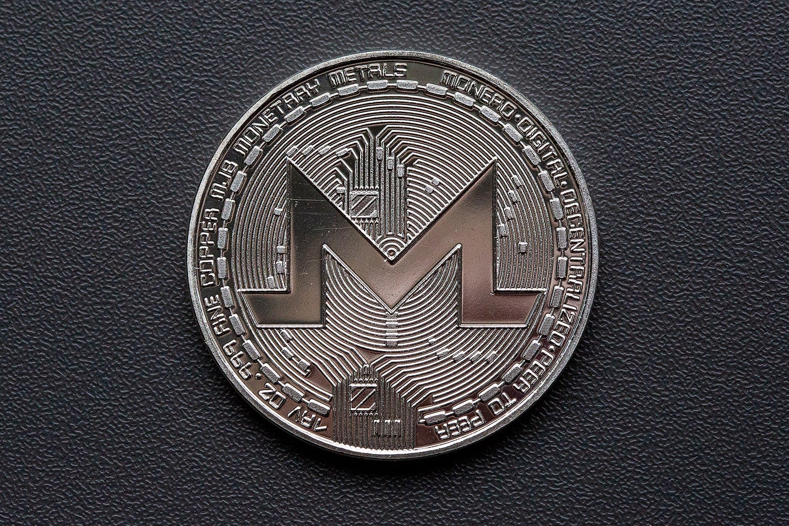 A novelty commemorative Monero coin with a large "M" in the middle.