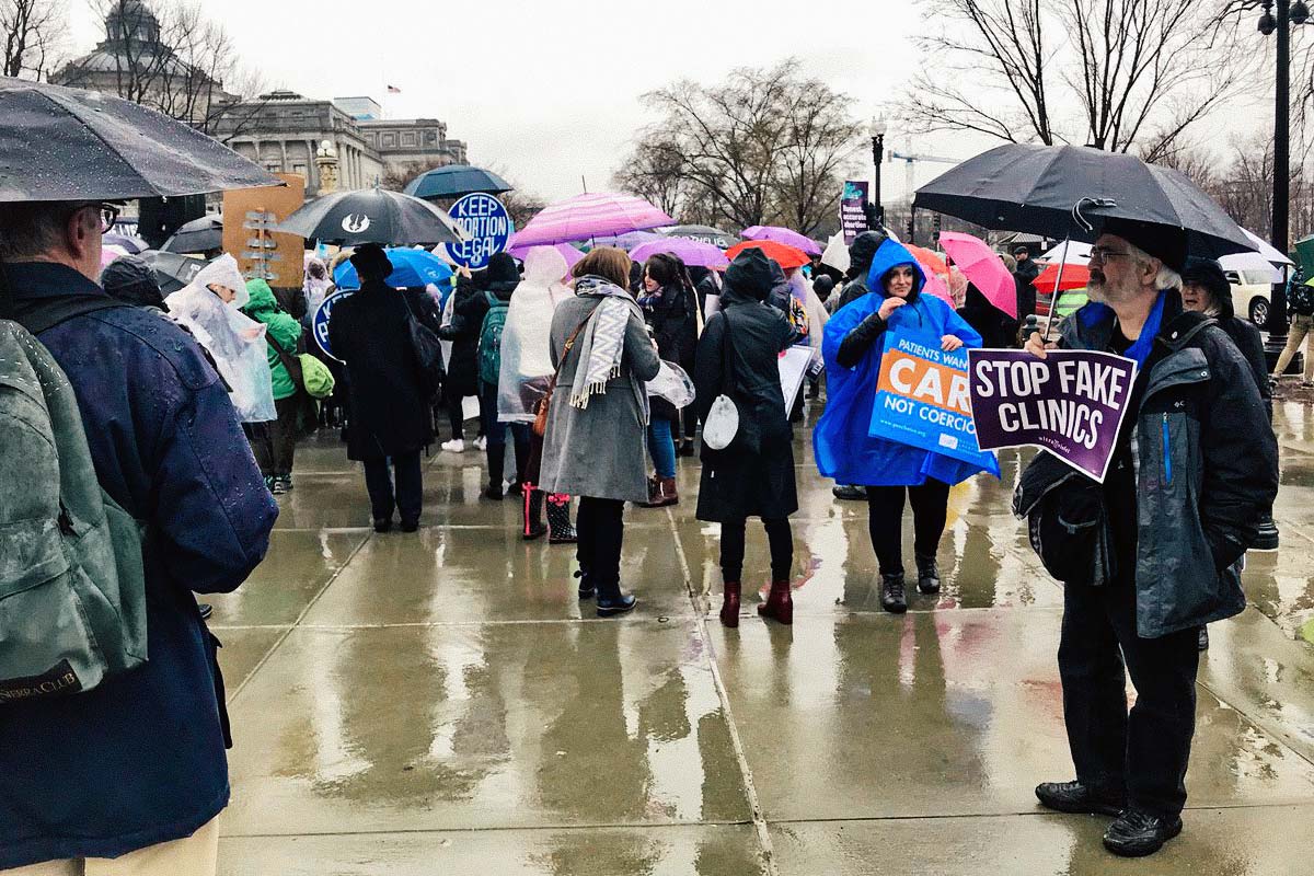 Demonstrators stand in the rain outside the Supreme Court on Tuesday.
