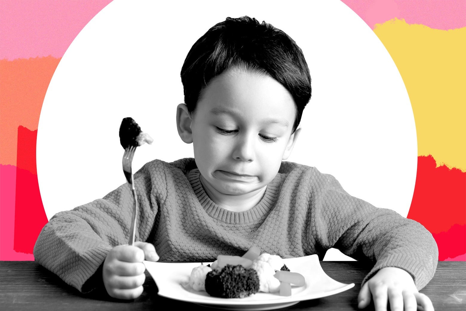 A kindergarten-aged child looking at his dinner plate in disgust.