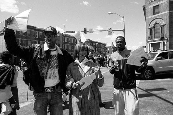 Maryland State Sen. Catherine Pugh stands with two young men handing out voter registration forms and pens to complete them with, Baltimore.