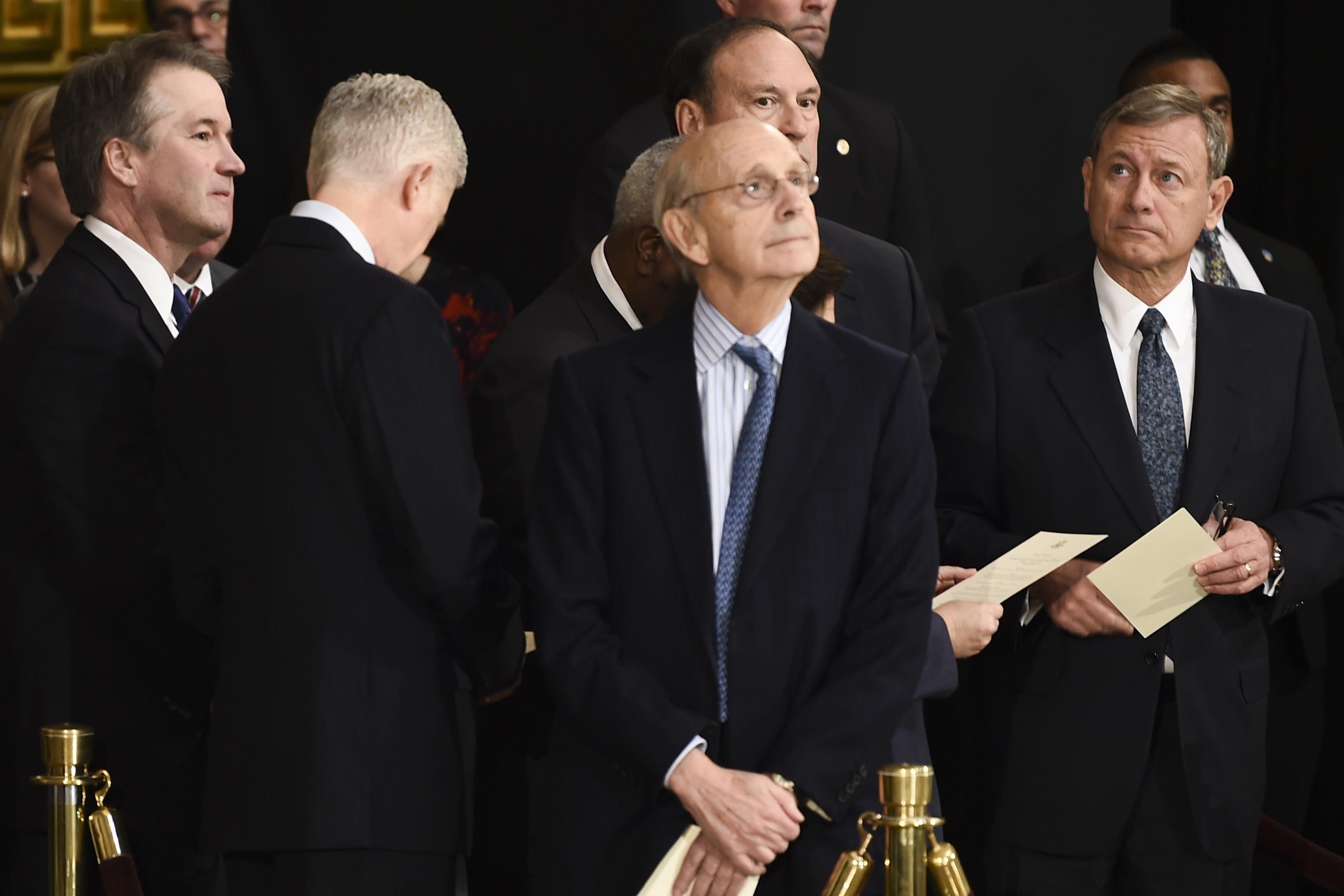 Members of the Supreme Court Brett Kavanaugh (L), Neil Gorsuch (2L), Stephen Breyer, and John Roberts (R) wait for the casket containing the remains of former US President George H.W. Bush to arrive at the U.S Capitol Rotunda on December 03, 2018 in Washington, DC.