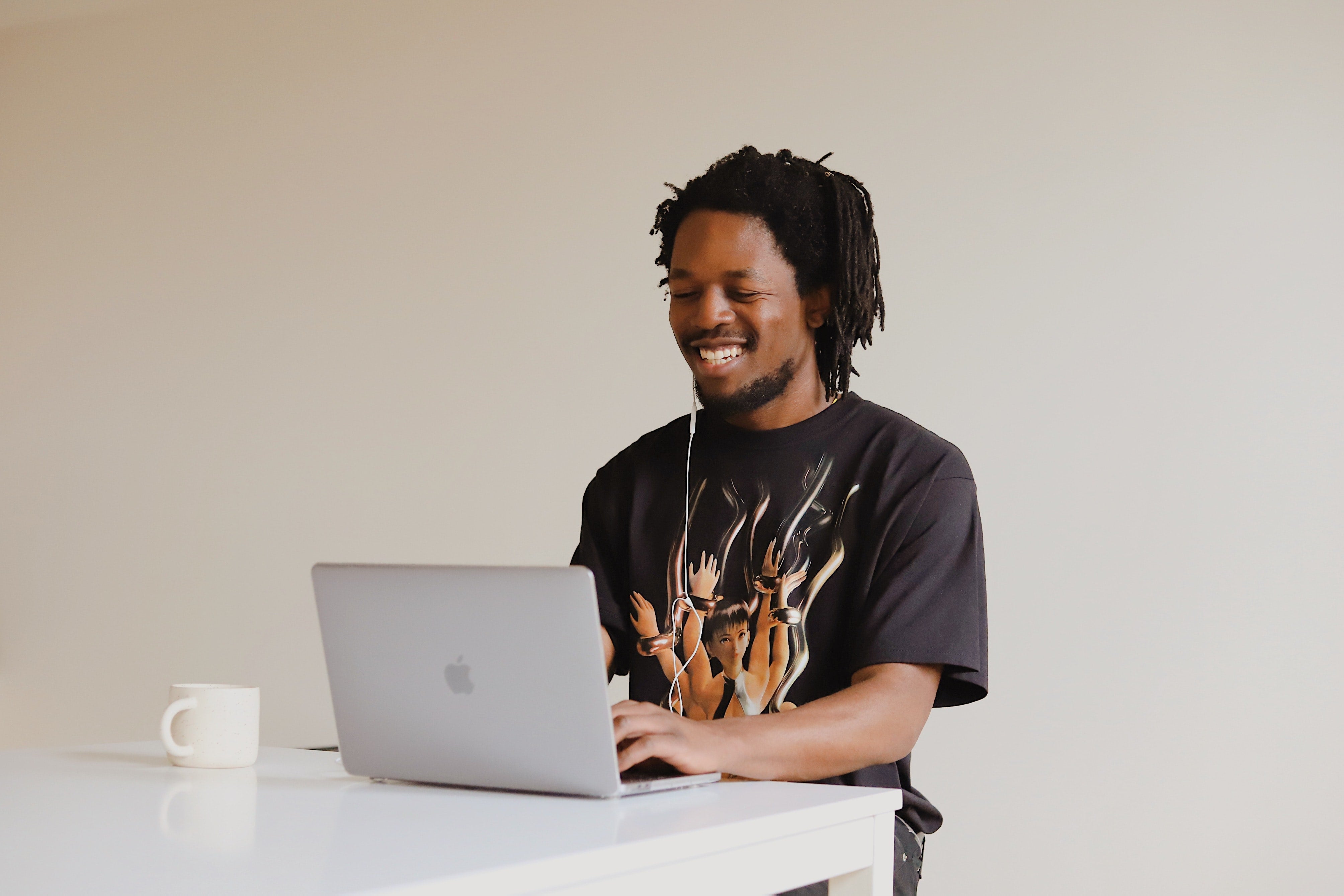 A man sitting at a laptop smiles