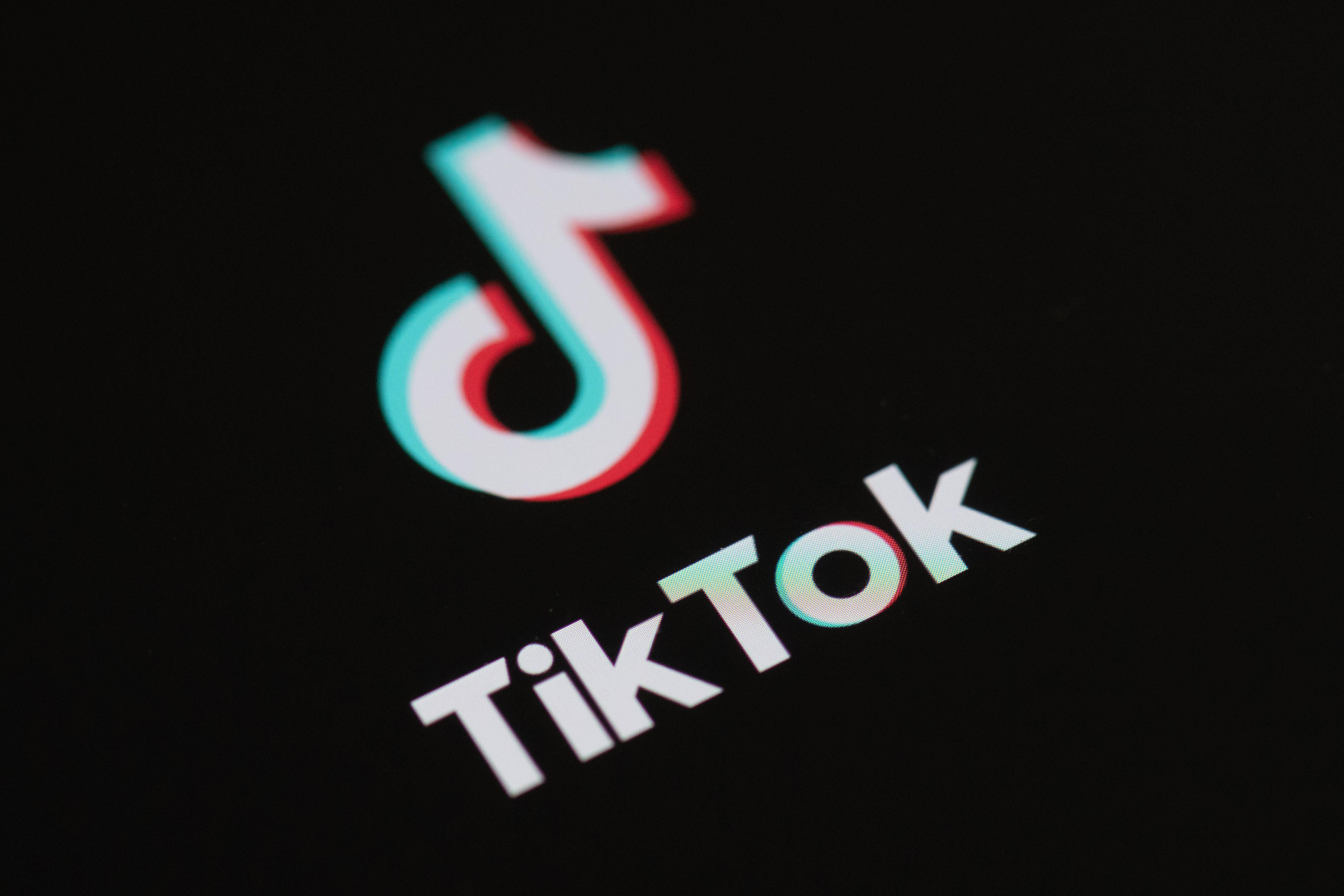 The TikTok logo on a black phone screen.