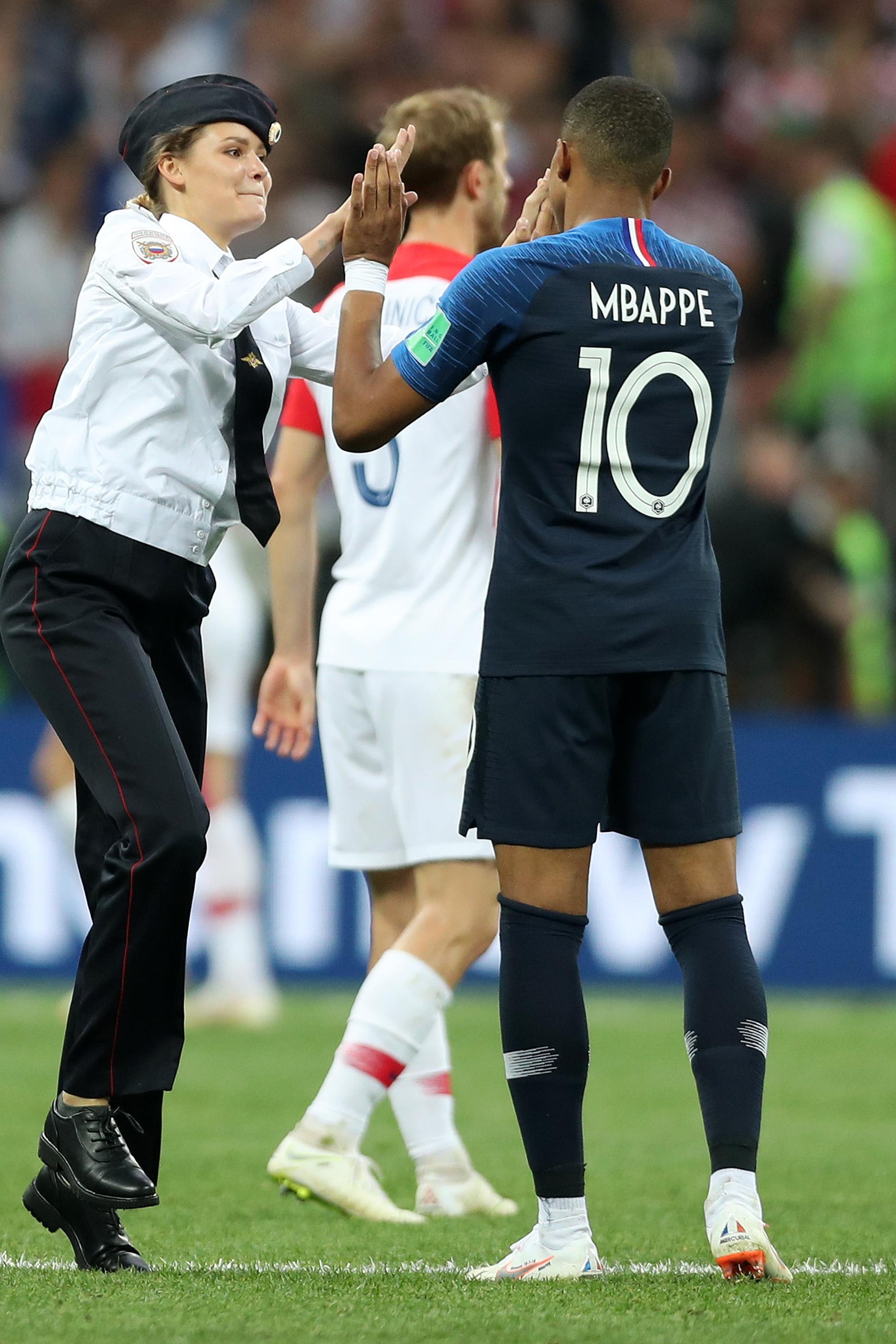 A pitch invader high fives Kylian Mbappe of France during the 2018 FIFA World Cup Final between France and Croatia at Luzhniki Stadium on July 15, 2018 in Moscow, Russia.