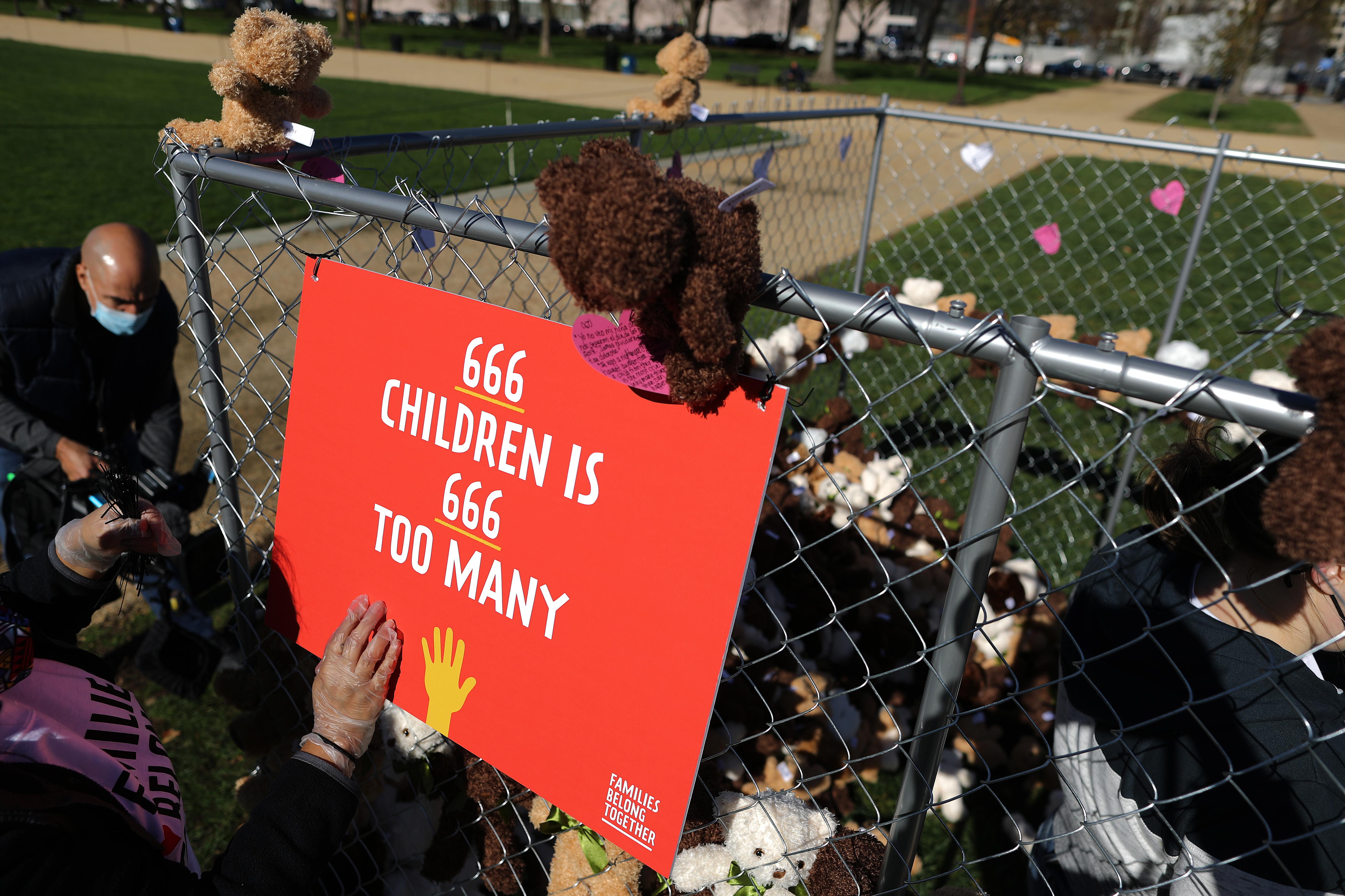 A cage full of teddy bears with a sign on it that says "666 children is 666 too many"