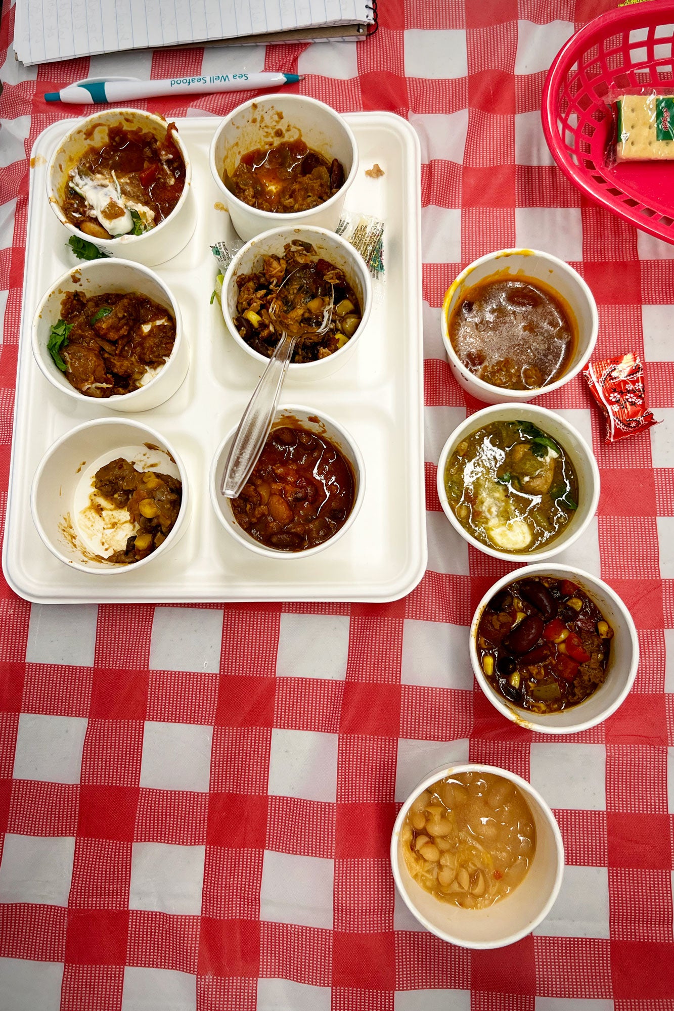 Ten paper bowls containing chili.