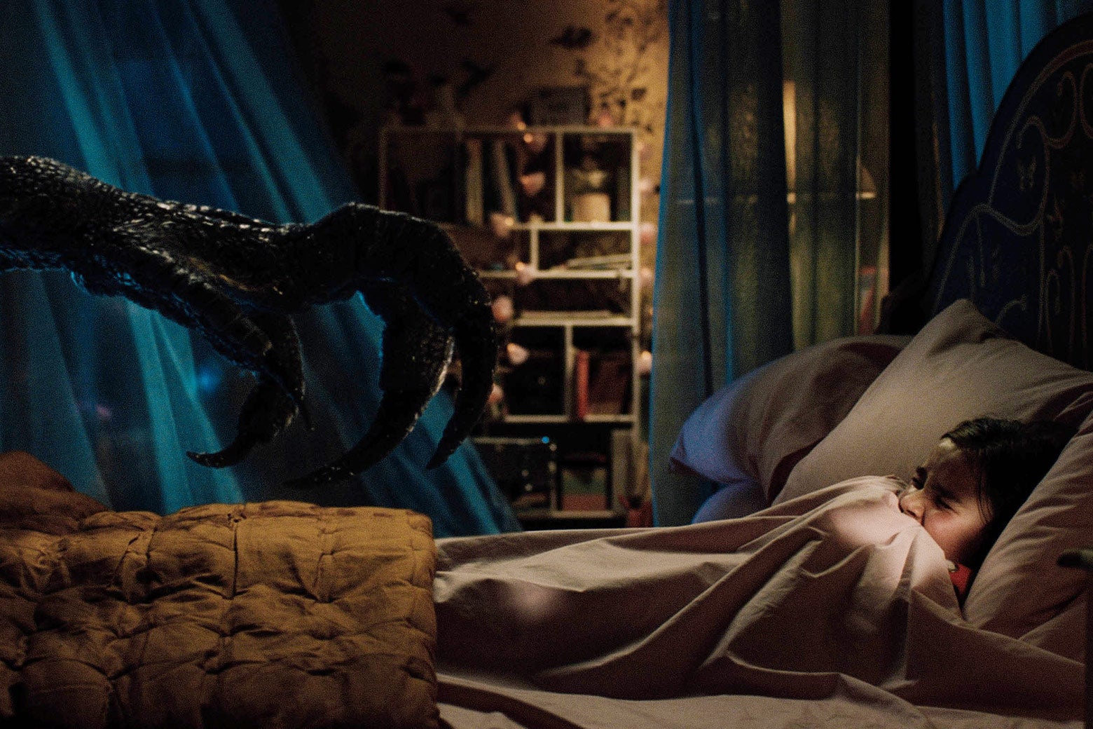 A scaly dinosaur claw reaches toward a child in a bed.