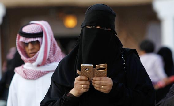 A woman using an iPhone visits the 27th Janadriya festival on the outskirts of Riyadh February 13, 2012. The two-week-long festival showcases Saudi Arabian culture and traditions.