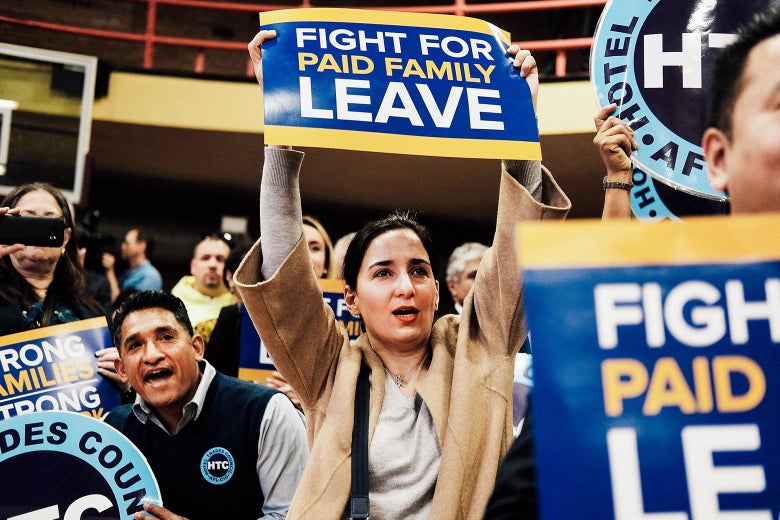 A woman holds a sign: "Fight For Paid Family Leave."