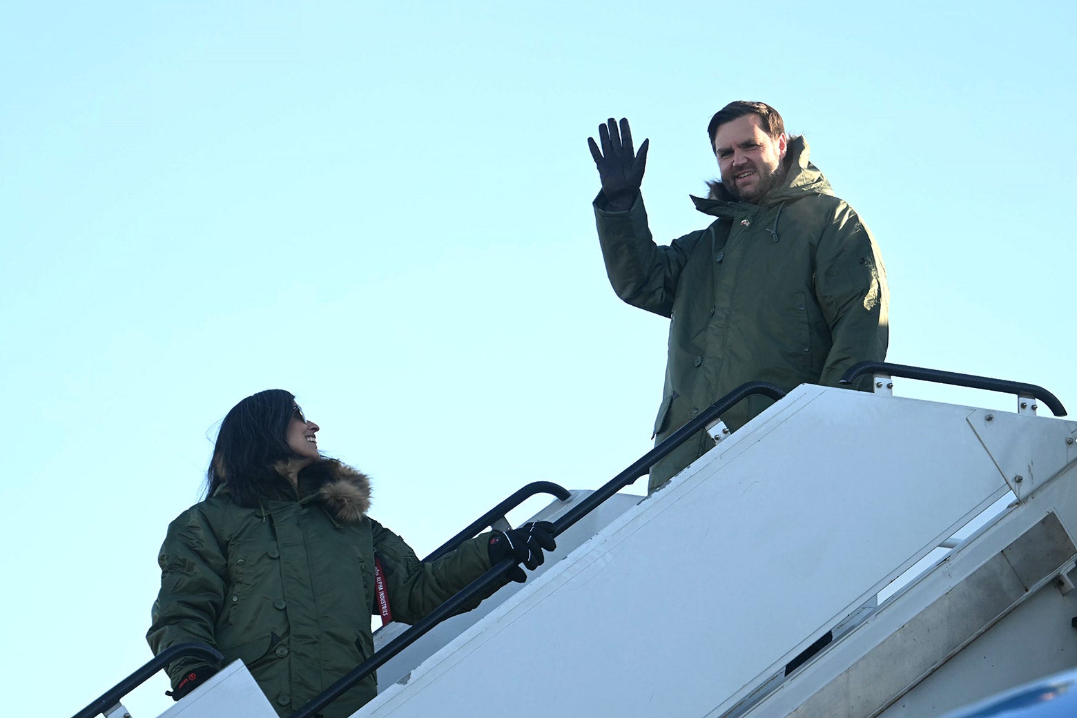 J.D. Vance waving while departing a plane with Usha Vance.