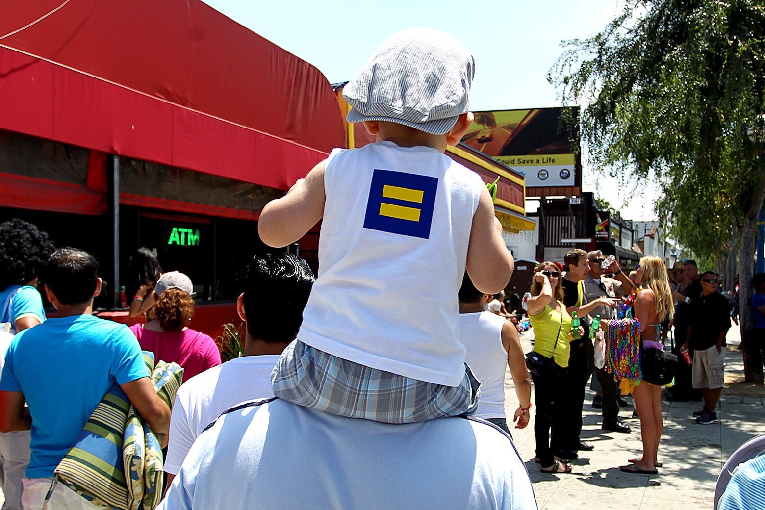 A child on the shoulders of an adult w/ an equal symbol on the back of his shirt.