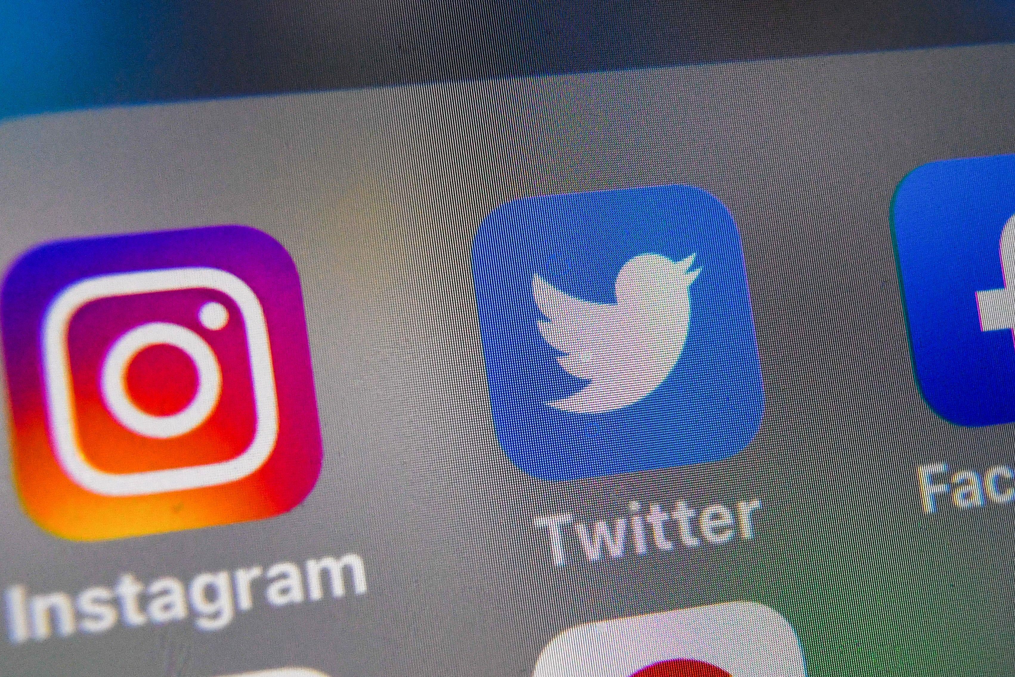 Instagram, Twitter, and Facebook logos on a smartphone screen