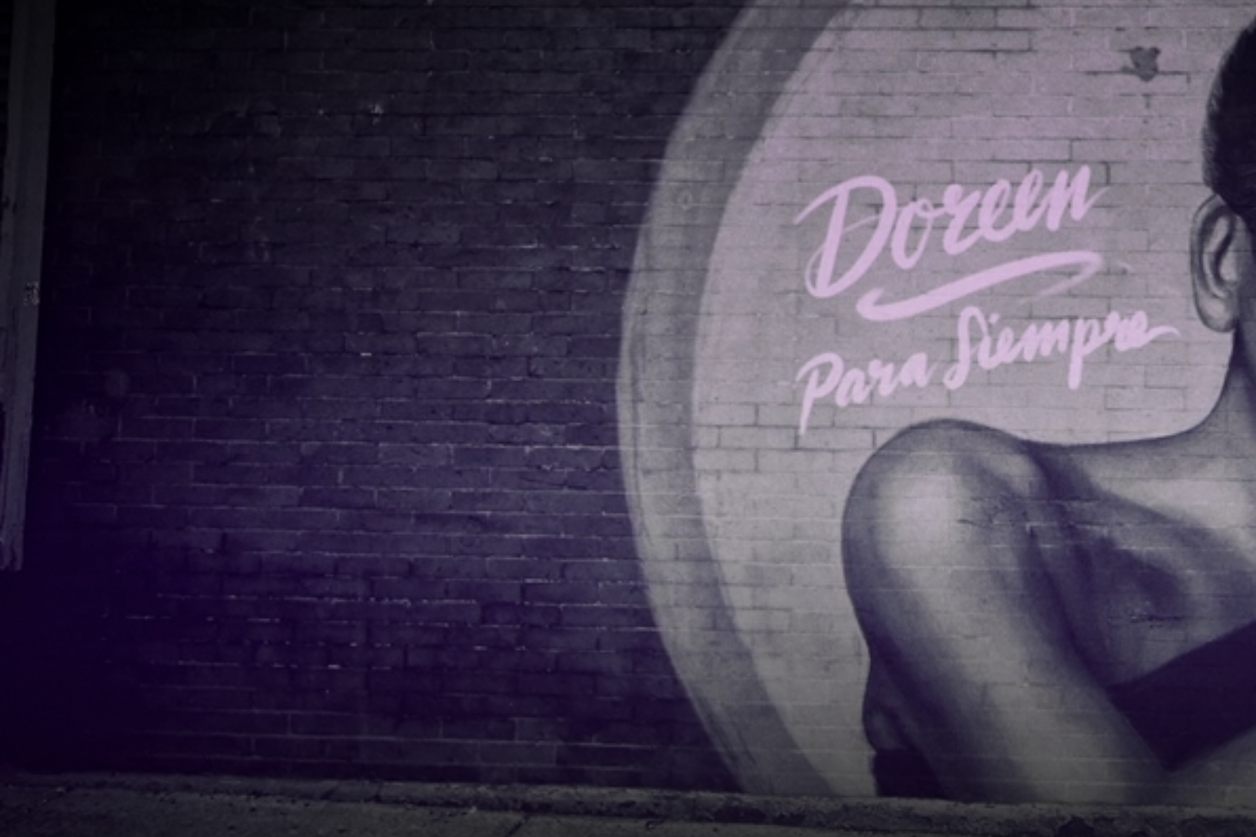 A graffiti painting on a brick wall showing a woman says “Doreen” and below that ”Para Siempre.”